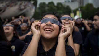 Students from Muchin College Prep react as the solar eclipse emerges from behind clouds in Millennium Park in Chicago on Aug. 21, 2017