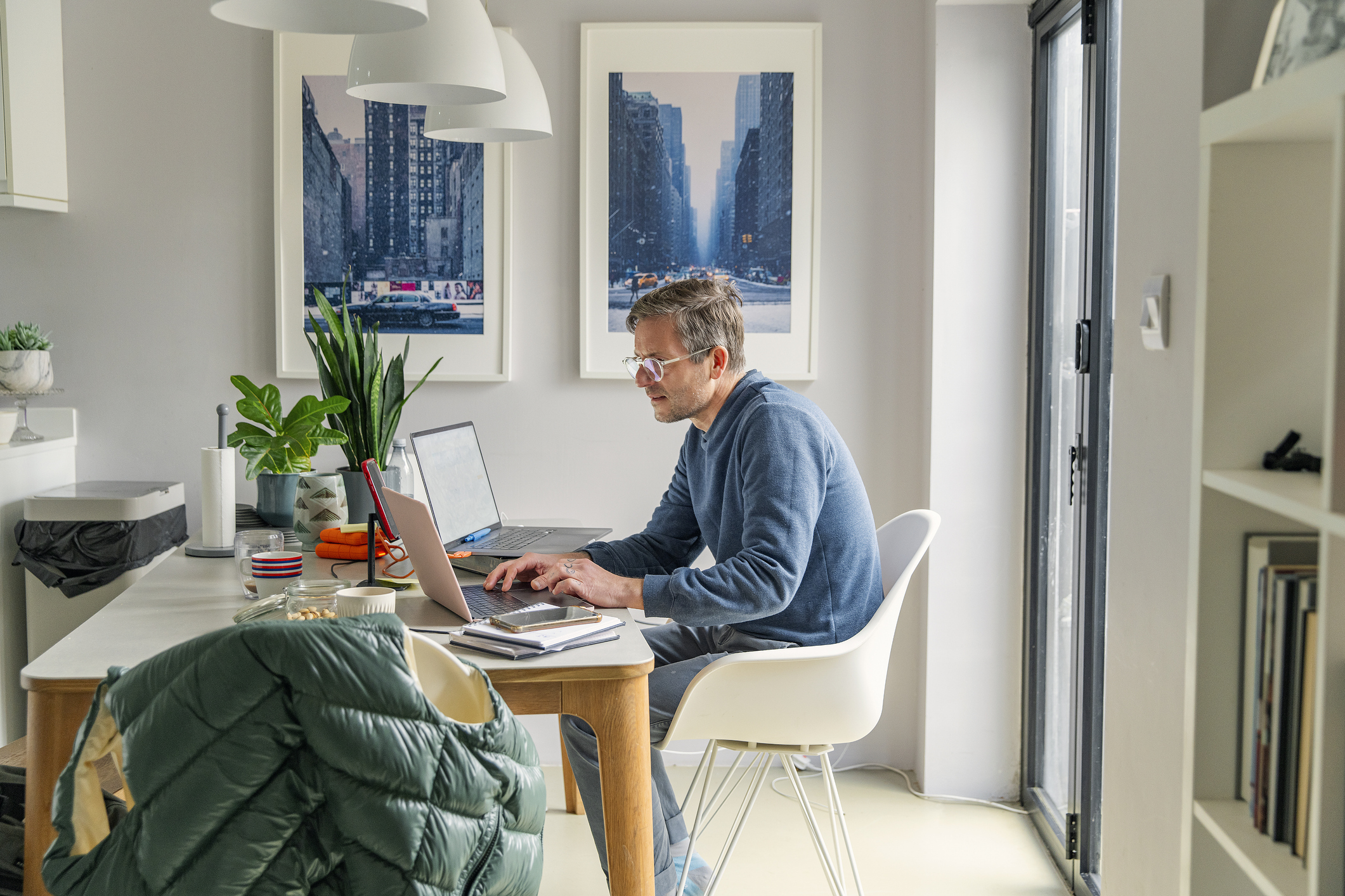 a man sitting at his desk scrolling on his laptop