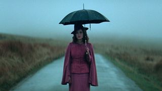 Sophie Rundle as Ada standing on the road and holding an umbrella in Peaky Blinders: The Immortal Man
