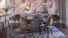 Purple motif wallpaper in dining room with round table, chairs, and fringe yellow lamp