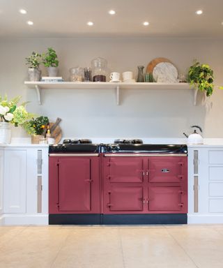 white country kitchen with a raspberry red AGA cooker and open shelving