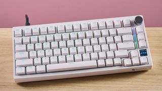 Gamakay TK75HE V2 on desk with pink wall in background