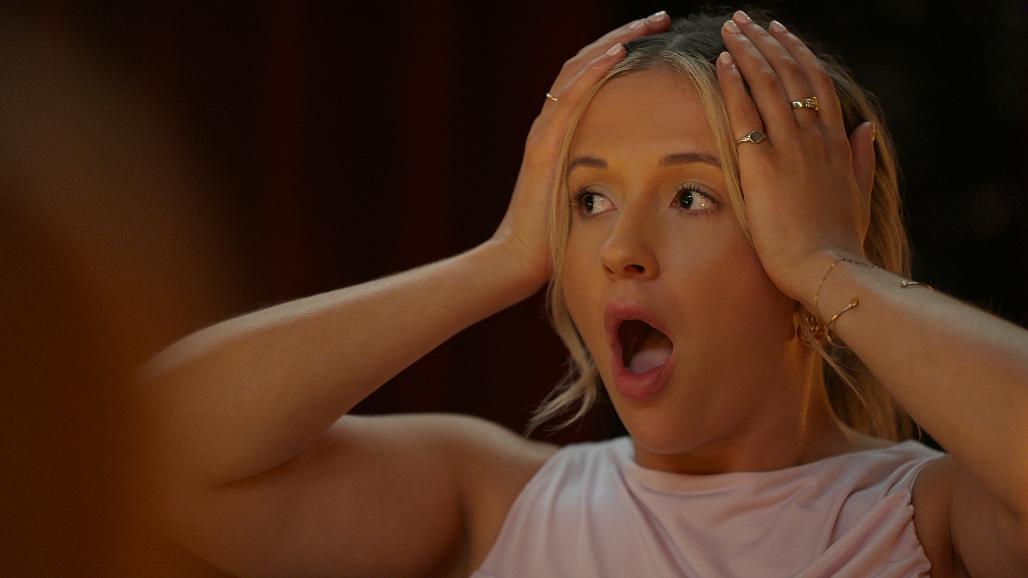 Kat Ellis looking surprised with her hands on her head in 'Million Dollar Secret' season 2.