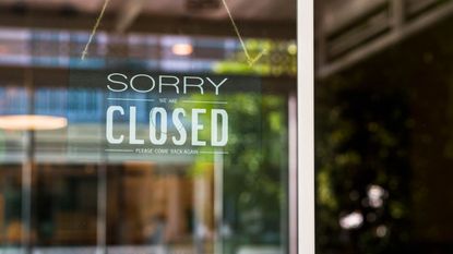 Shopper wearing COVID mask walks past closed stores