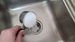 Salt being poured down a garbage disposal unit