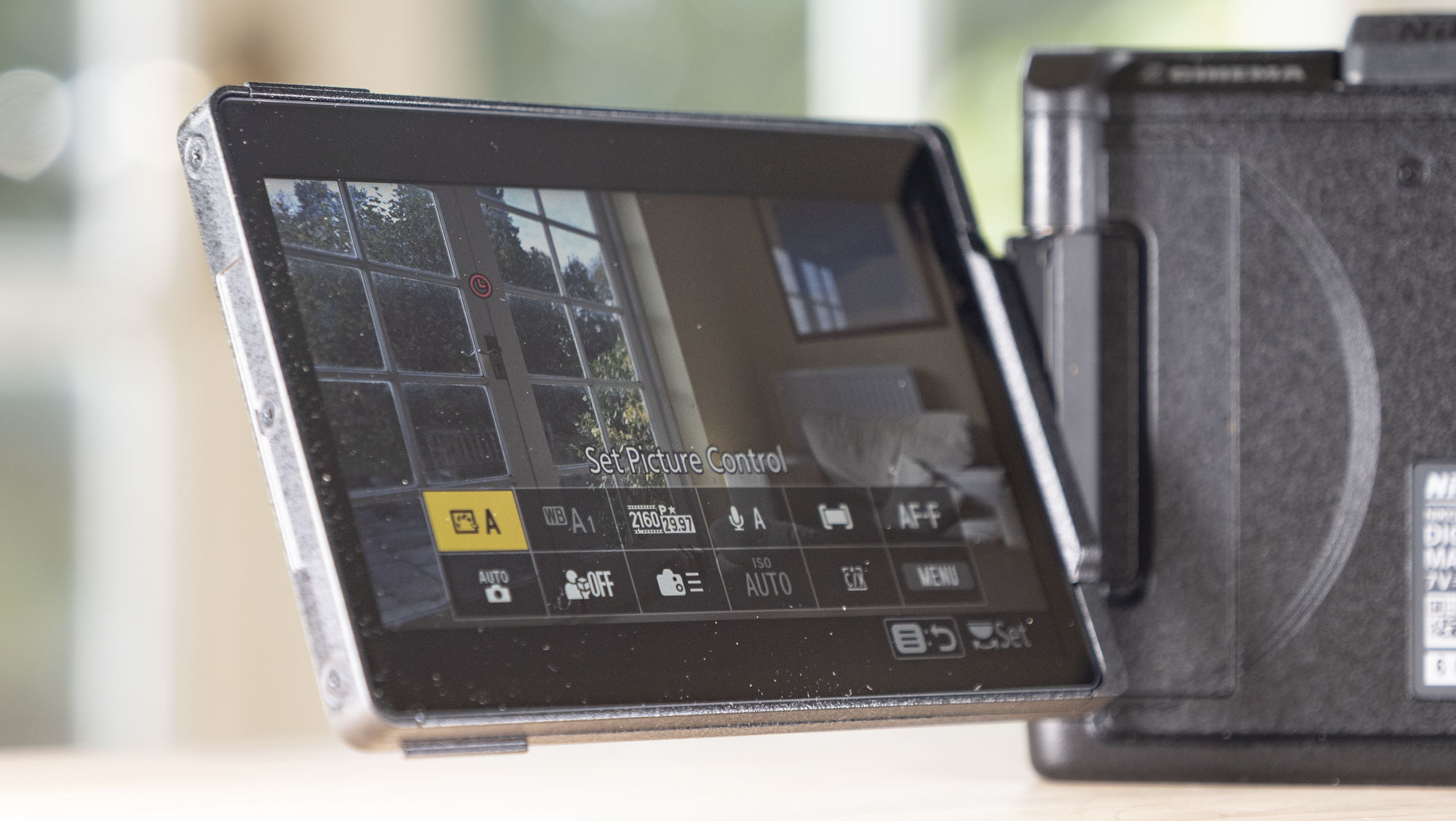 Nikon ZR product photos – camera on a wooden table, screen flipped out