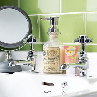 Lotion, chrome taps and grey mirror on top of white Savoy bathroom basin