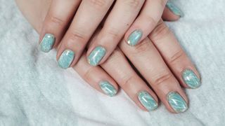 person with light blue watercolor nails