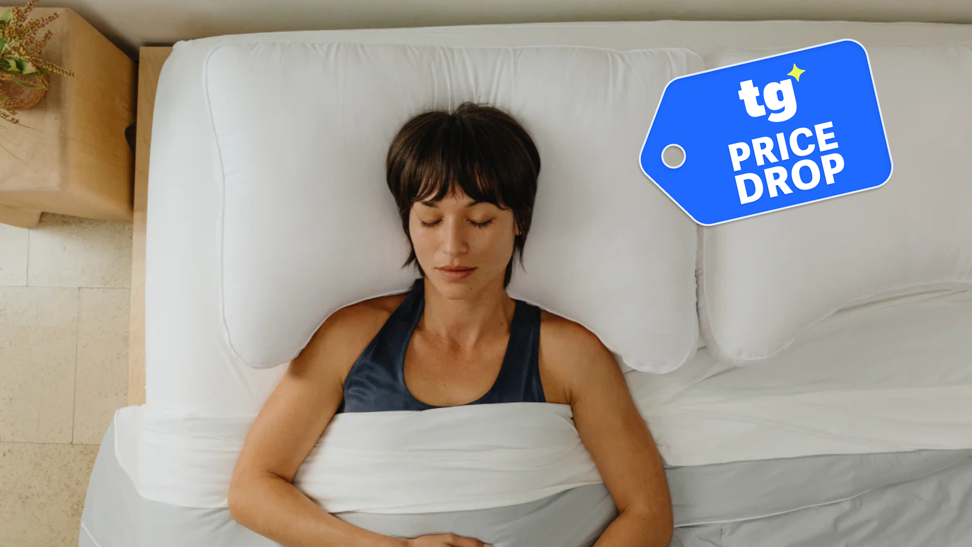 Woman sleeping on the Coop Essence Crescent Pillow in a brightly lit room