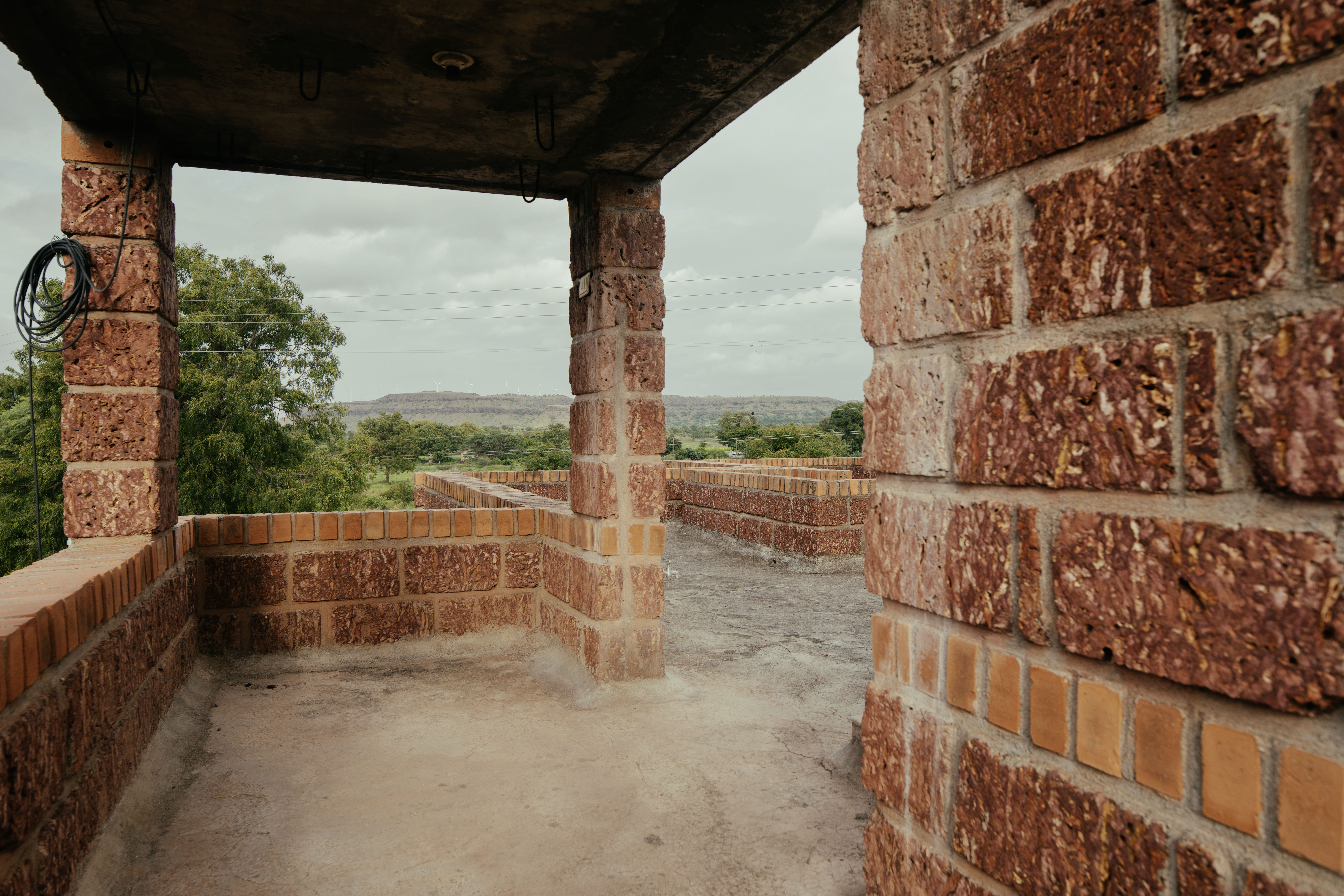 Kanade brothers house in India, brick structure in green surrounds