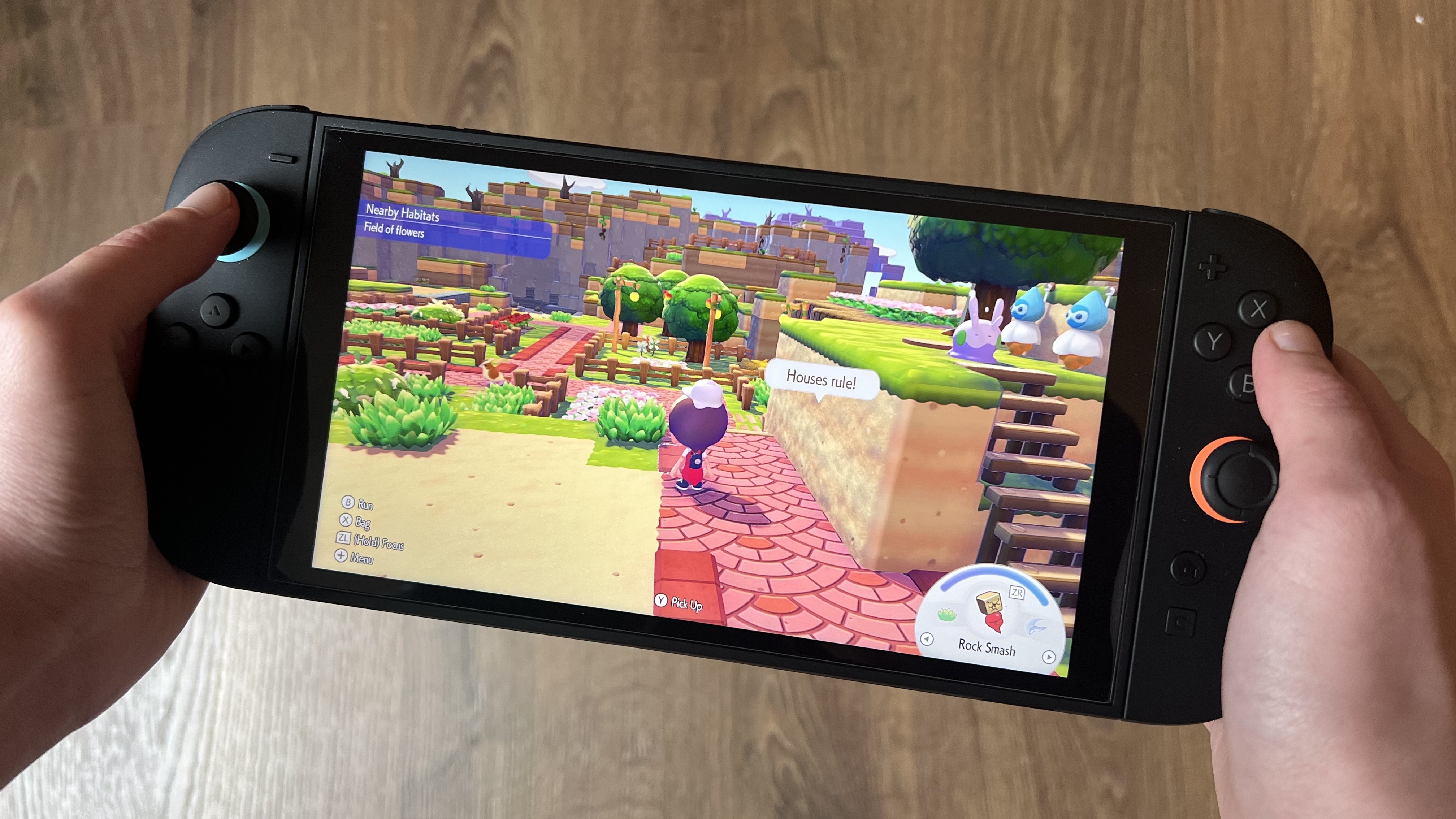 Hands holding Nintendo Switch 2 with Pokemon Pokopia running on screen