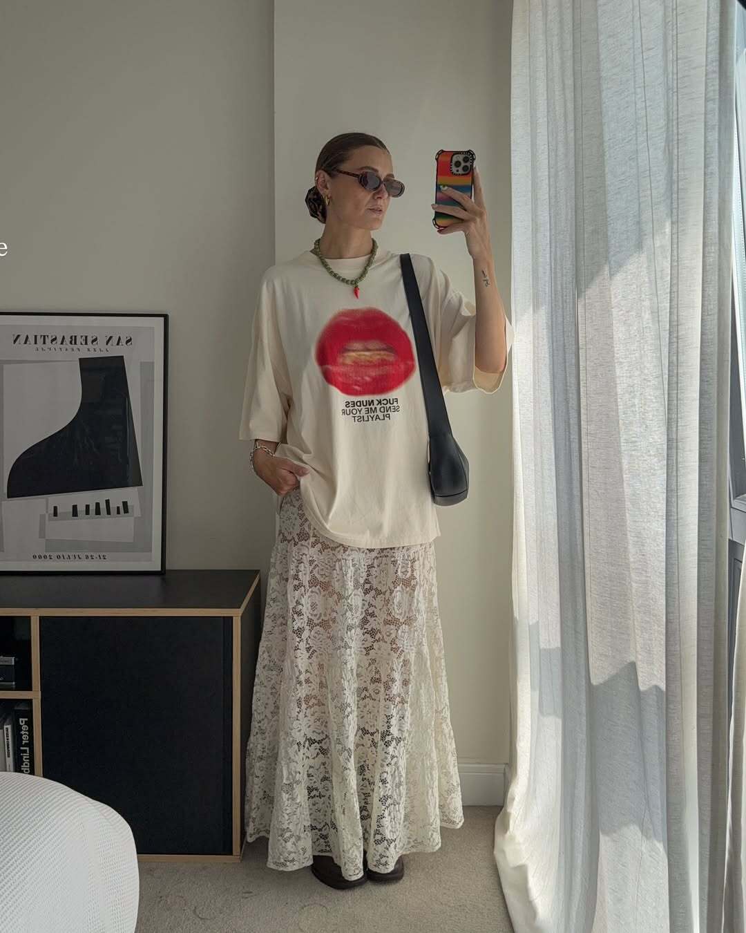 Fashion person Millie wears a white lace skirt brown boots and a graphic t-shirt.