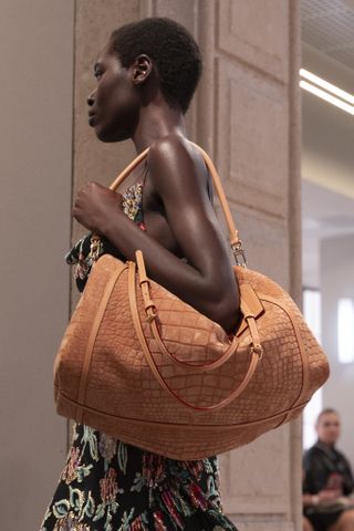 A model carried a piece of Louis Vuitton L'Express luggage in camel nubuck leather at the F/W 25 show.