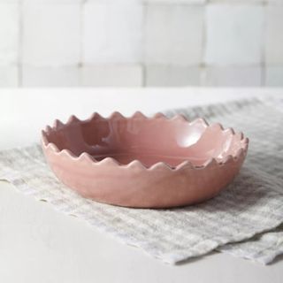 Pink scalloped bowl on gray napkin
