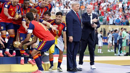 Rodri #16 of Spain lifts the trophy while US President Donald Trump and FIFA President Gianni Infantino look on during the trophy ceremony following the FIFA World Cup 2026 Final