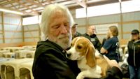 Geezer Butler cradling a beagle