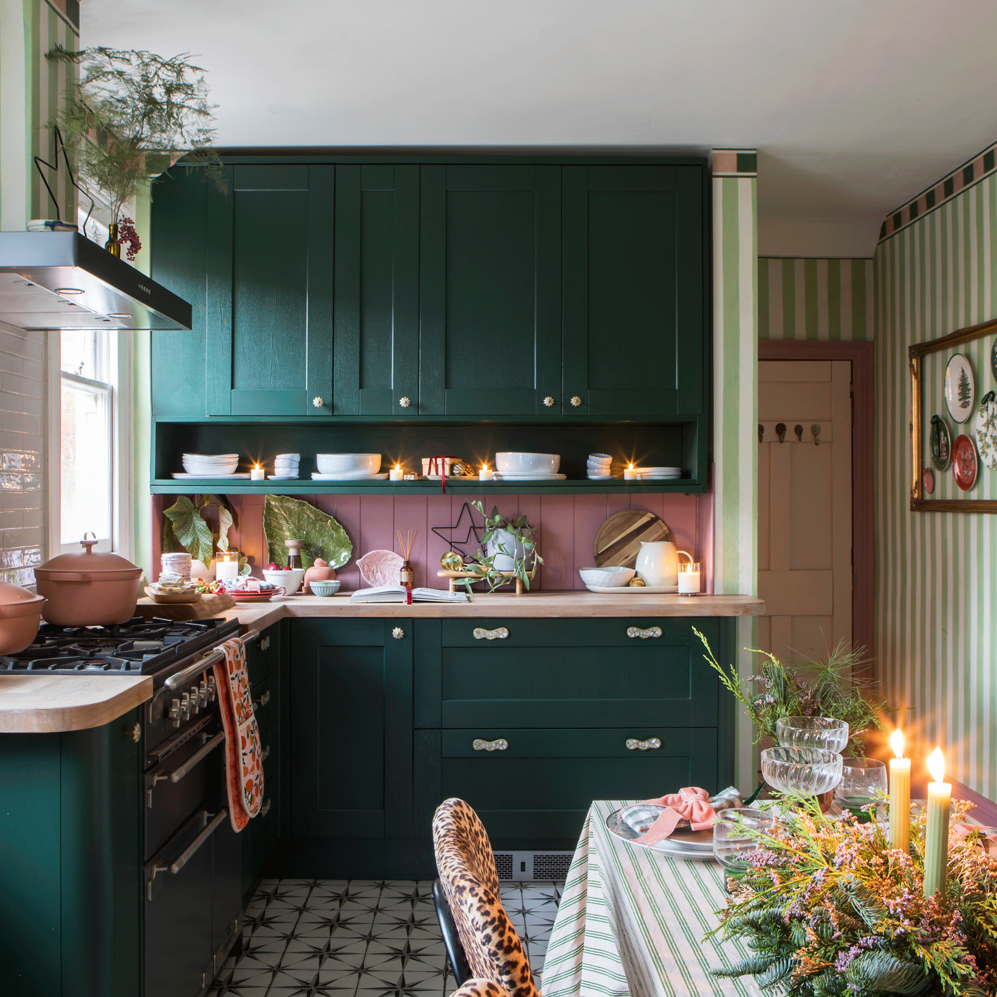 a green and pink kitchen with green and white striped wallpaper and a dining table with a matching tablecloth