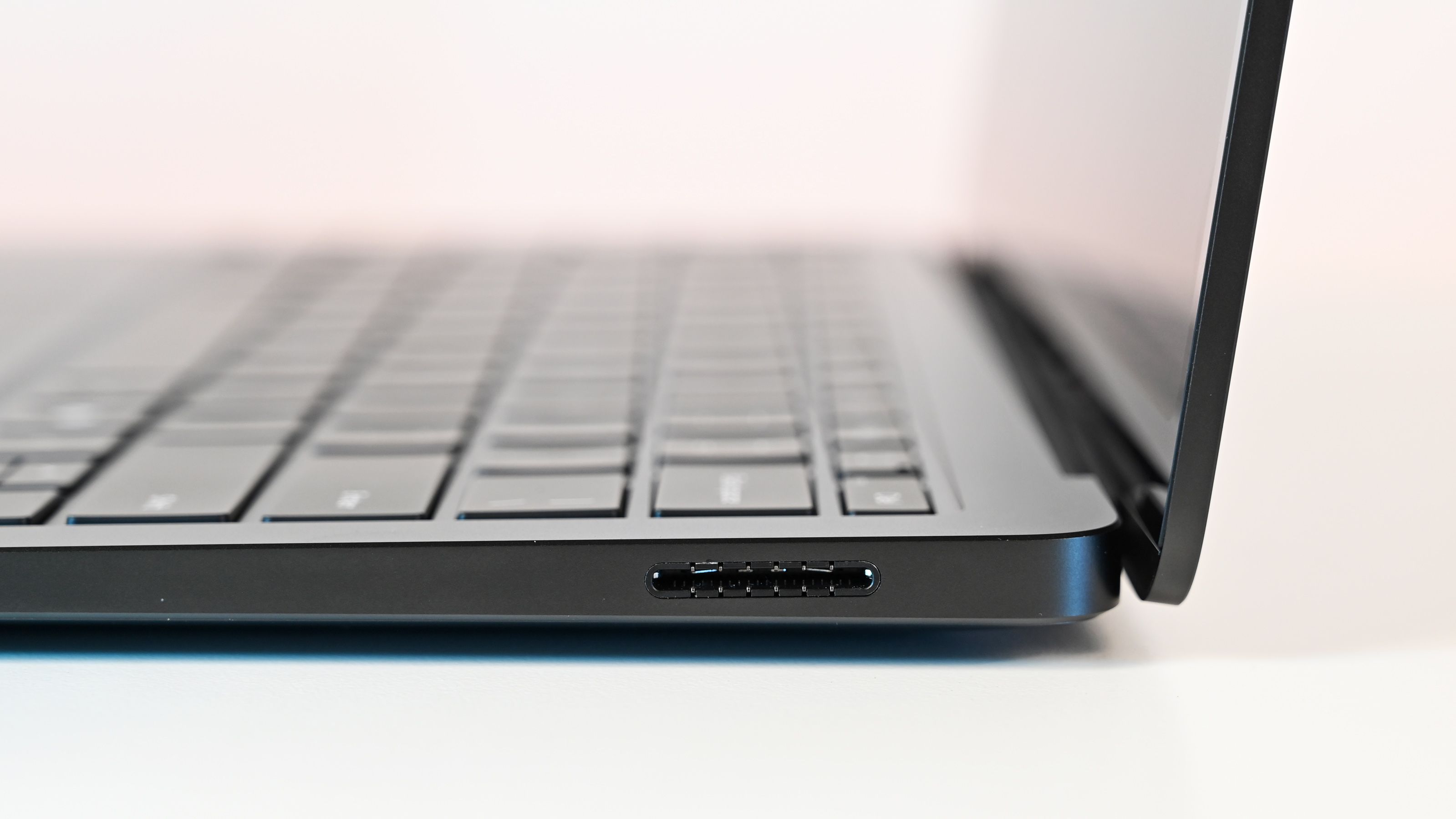 Surface Laptop for Business 8th Edition viewed from the side; focus on the slim design and keyboard. Screen slightly angled open, emphasizing a modern and minimalist aesthetic.