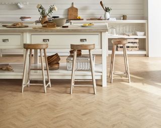 A kitchen with wood-effect vinyl kitchen flooring ideas in a pale oak style.