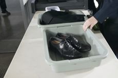 Shoes and Clothes in Containers on a table at Airport Customs