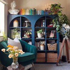 A living room with an IKEA KALLAX unit painted in navy blue and elevated with arched appliques to the front