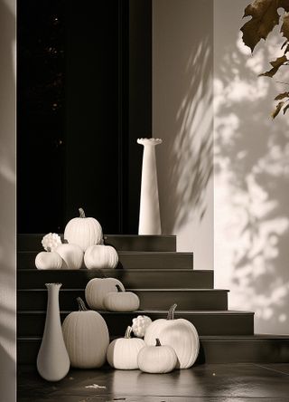 A front doorway with white pumpkin decor