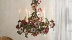 Anthropologie candle chandelier styled with white taper candles in a neutral dining room