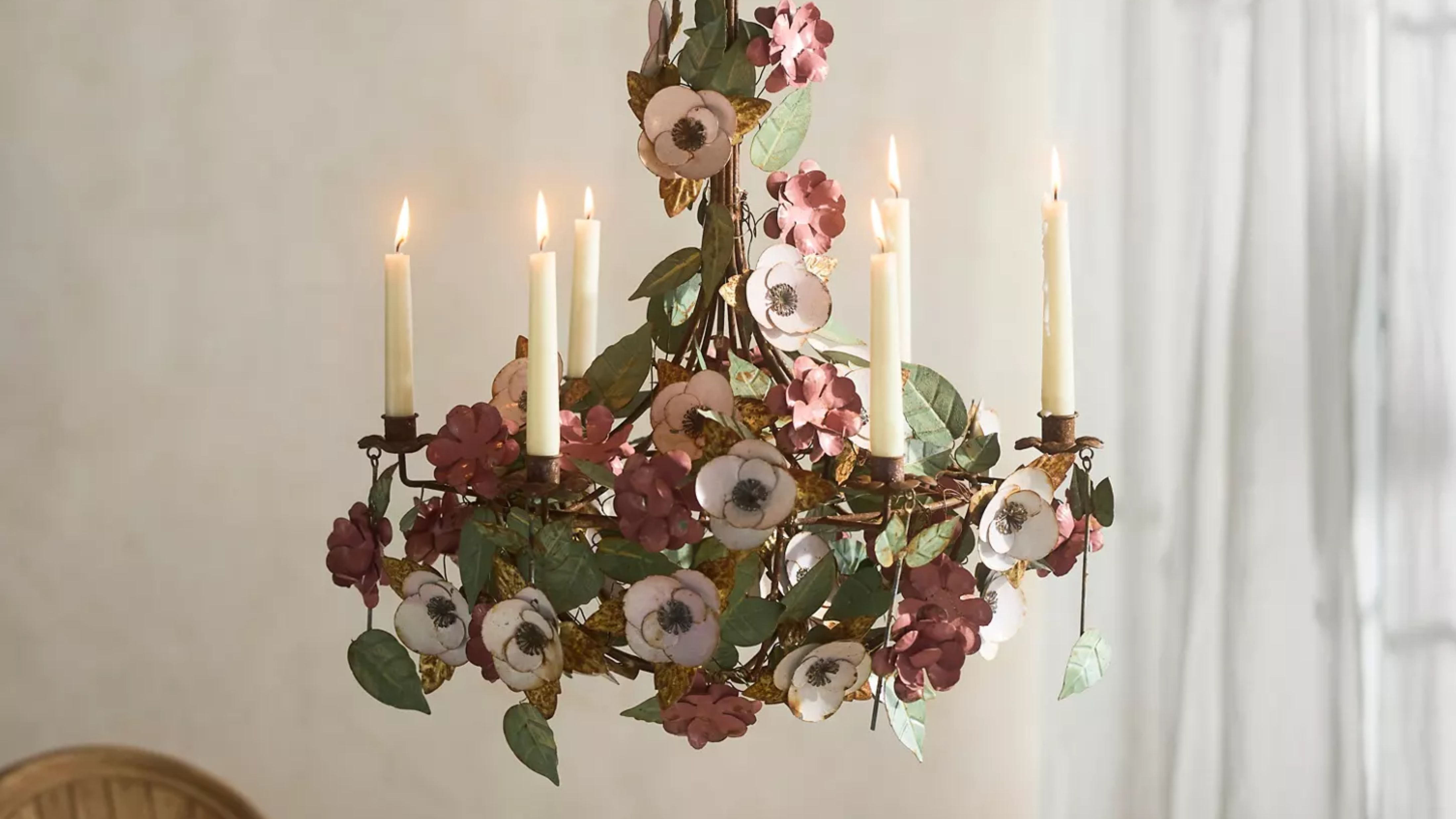 Anthropologie candle chandelier styled with white taper candles in a neutral dining room