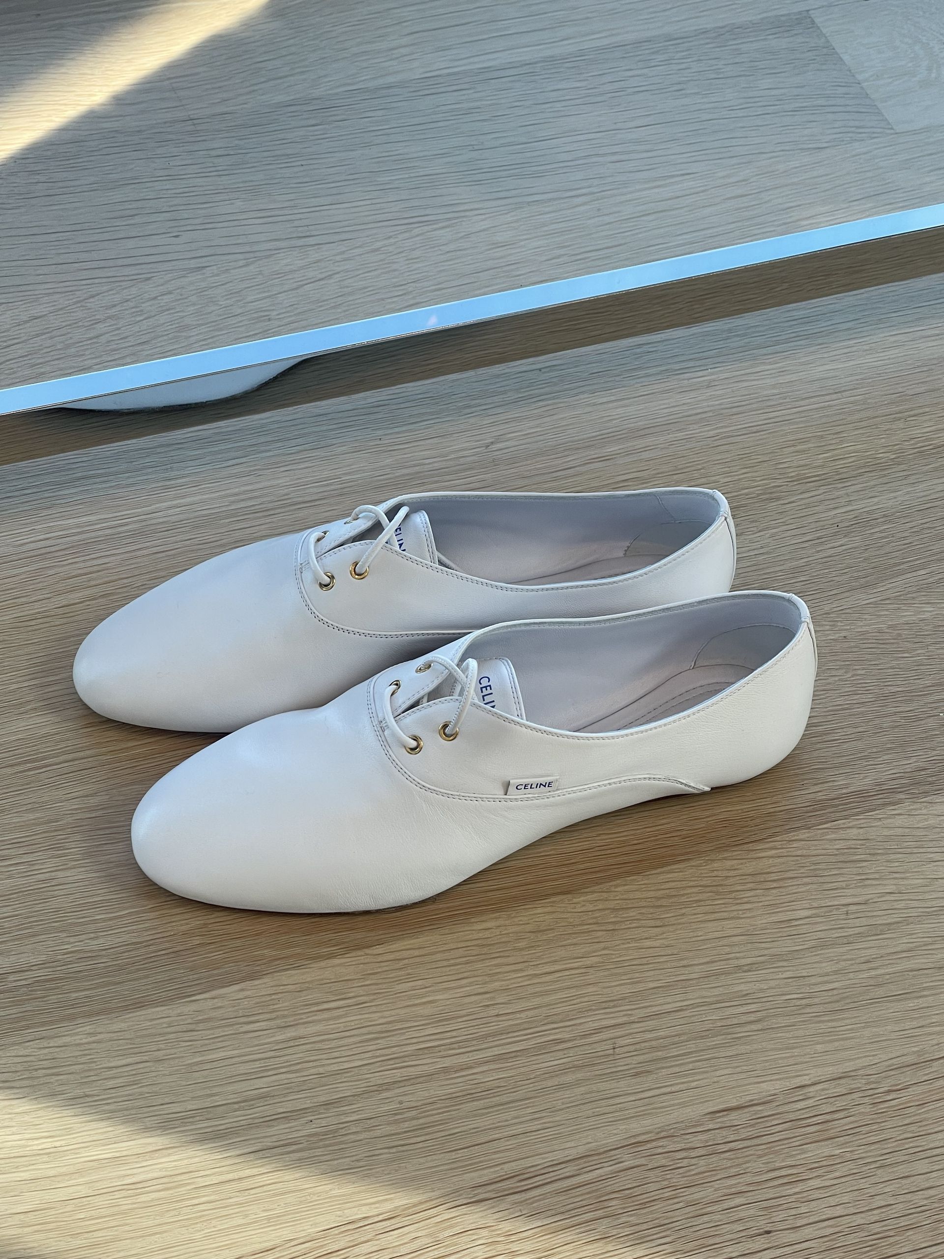 a pair of white Celine lace-up ballet flats