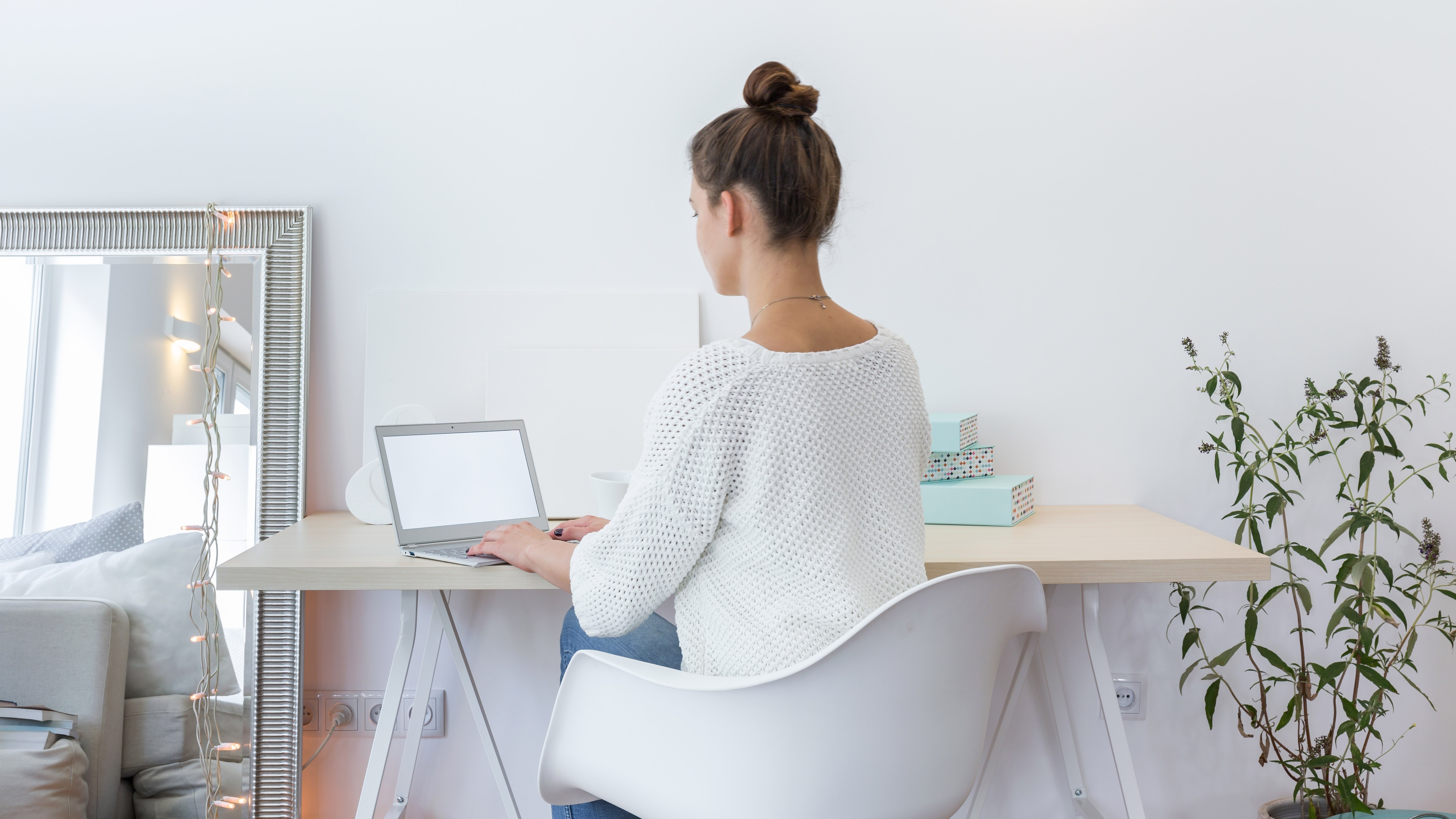 A woman working in her home office next to a mirror