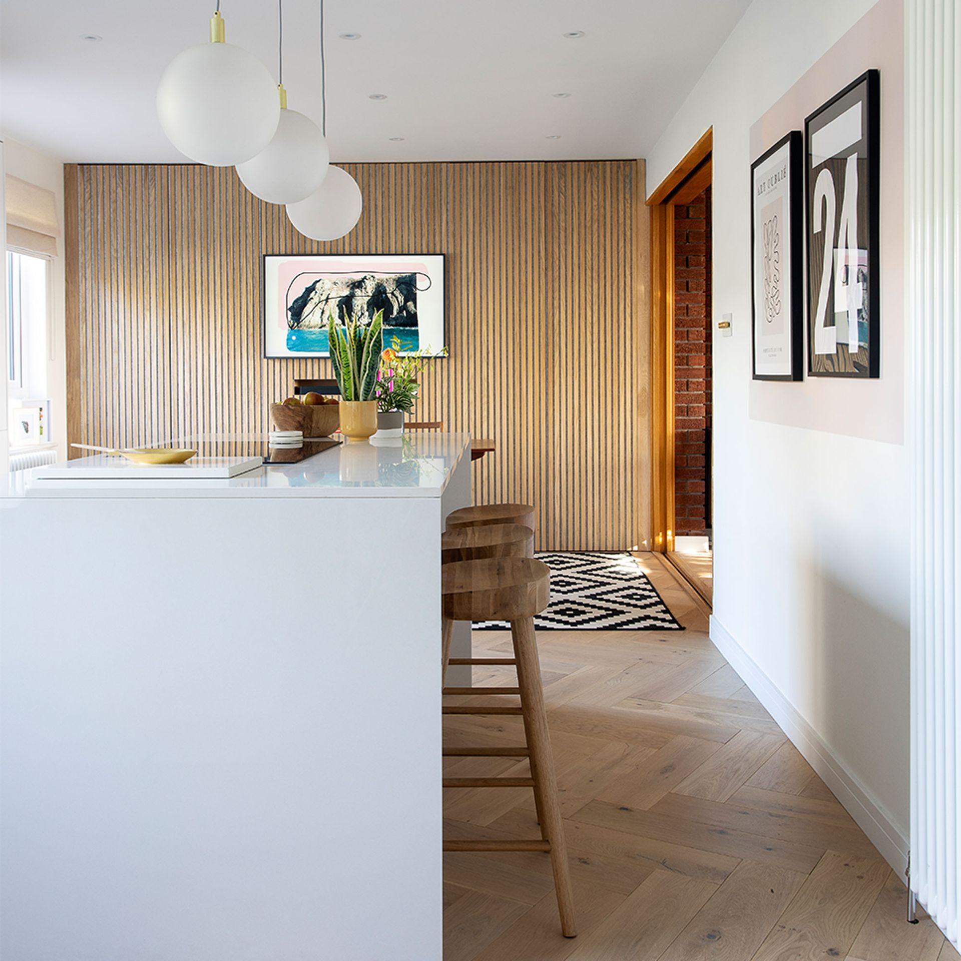 white kitchen with island and wood veneer feature wall