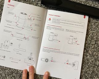 Ultenic U12 Vesla cordless vacuum cleaner instructions held open by a person's hand, visible at the bottom of the image