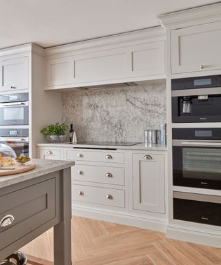 greige kitchen cabinets with marble backsplash