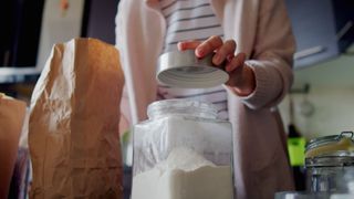 woman placing lid on flour container