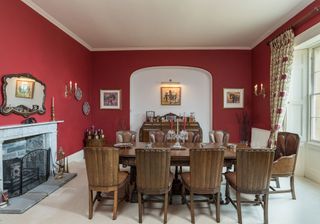 dining room with red wine walls and candelabra style walls lights