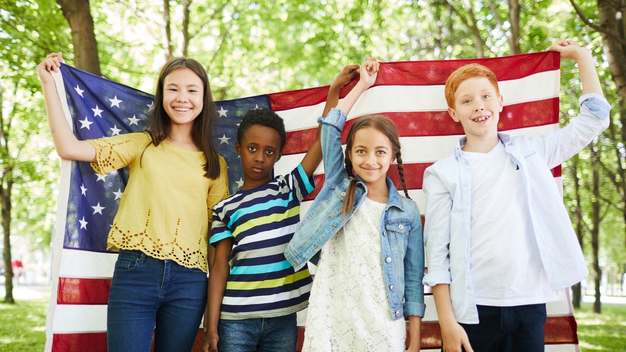 Four kids holding up an American flag