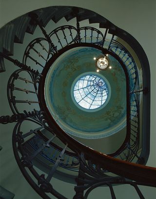 View up through a spiral staircase to a roof-light