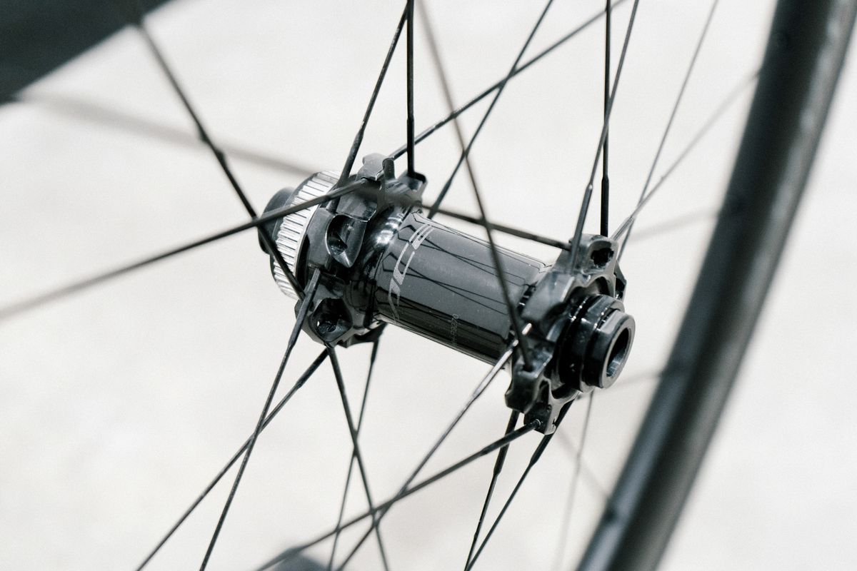 An aero road wheel stands against a white wall