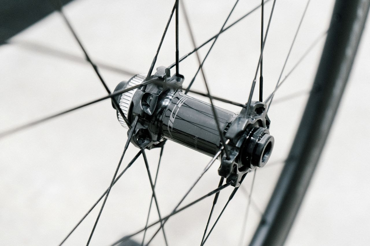 An aero road wheel stands against a white wall