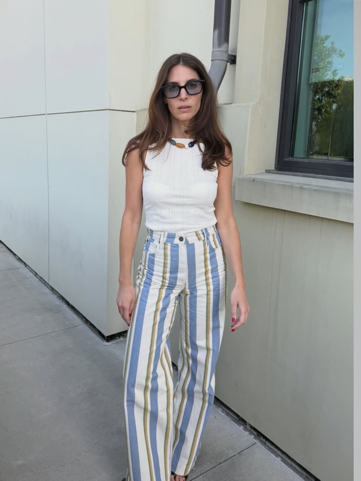 a woman wears striped pants with flats and a tee.