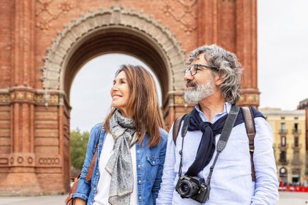 Mature married couple enjoying vacation visiting a European city. Senior tourists walking in Barcelona during summer holidays.