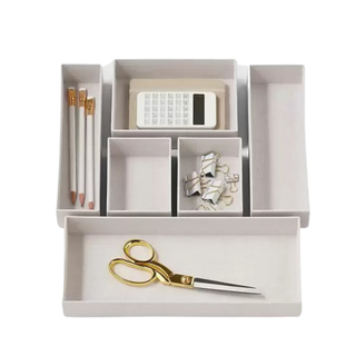 A cream desk organizer with stationery in it