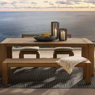 Canyon Outdoor Dining Table against a sea view and a sunset.