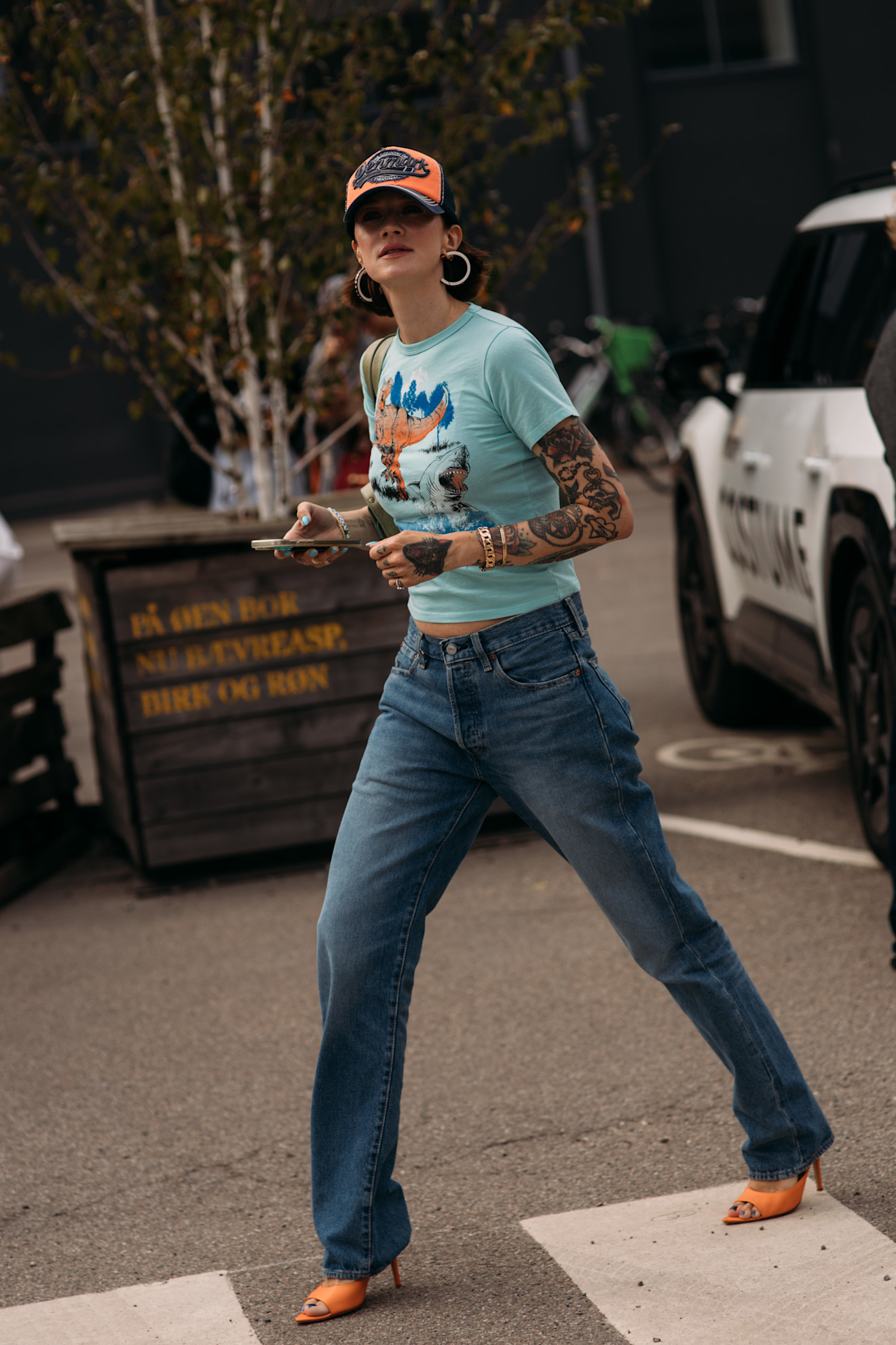 woman wearing a graphic t-shirt, jeans, and heels