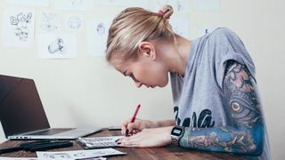 website builder for artists: woman sketching on paper