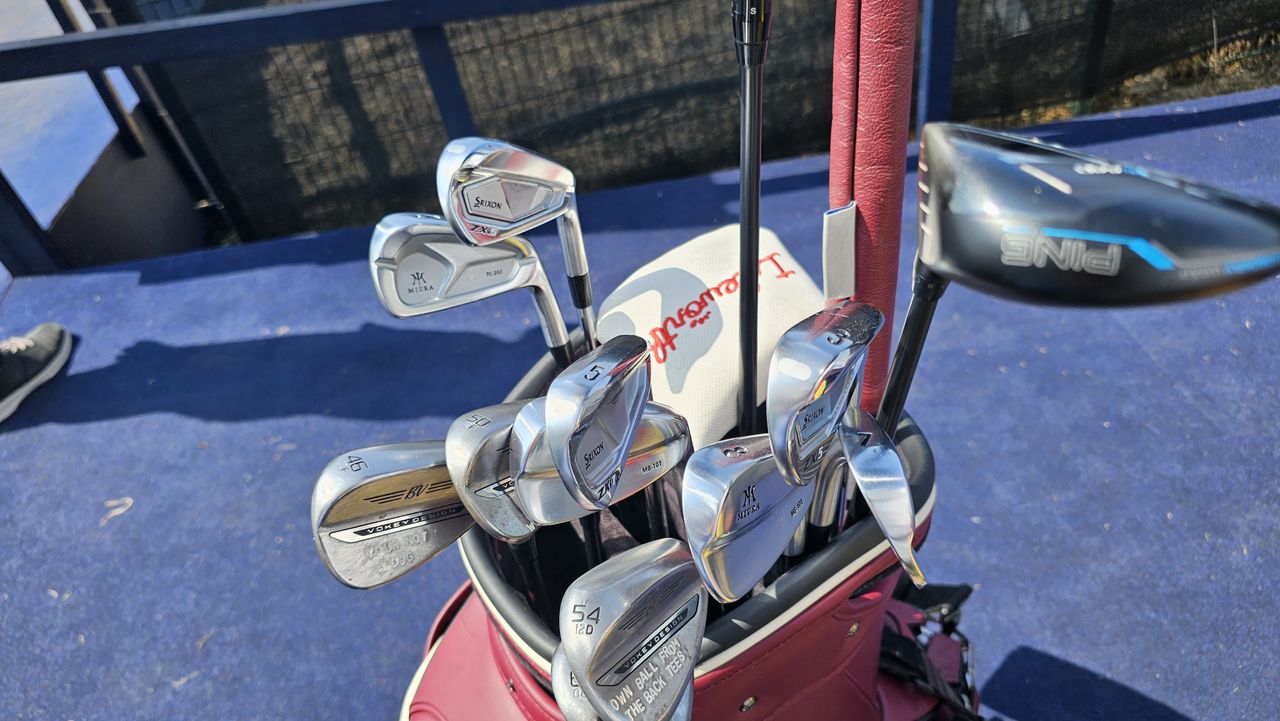 A golf bag with irons and wedges in view