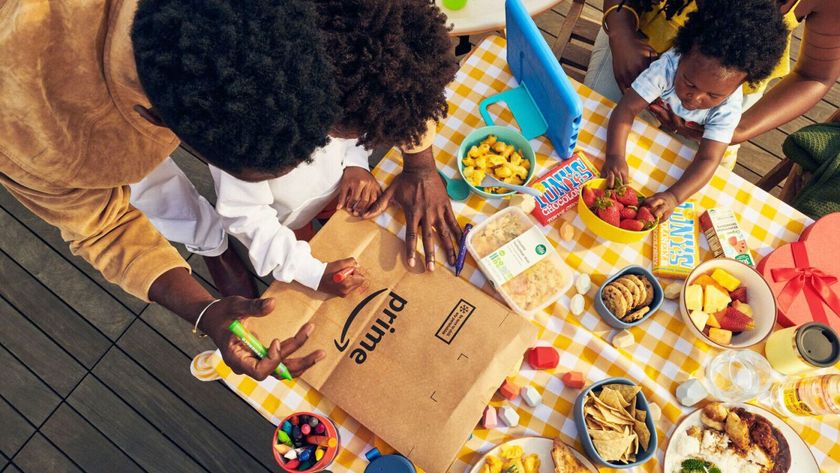 Family at a picnic table with Amazon packaging on the table and a fire kids tablet