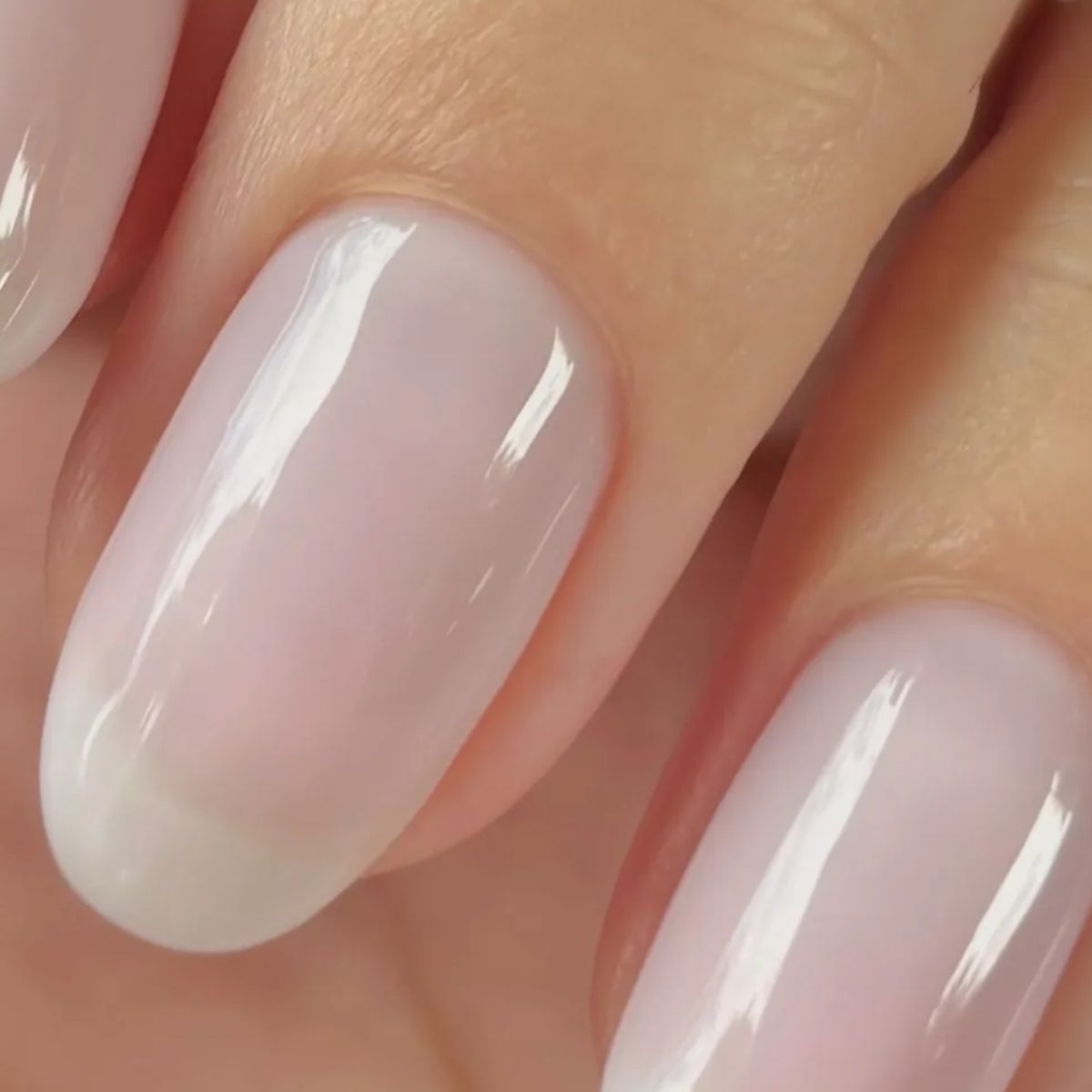 A close-up picture of a sheer milky manicure