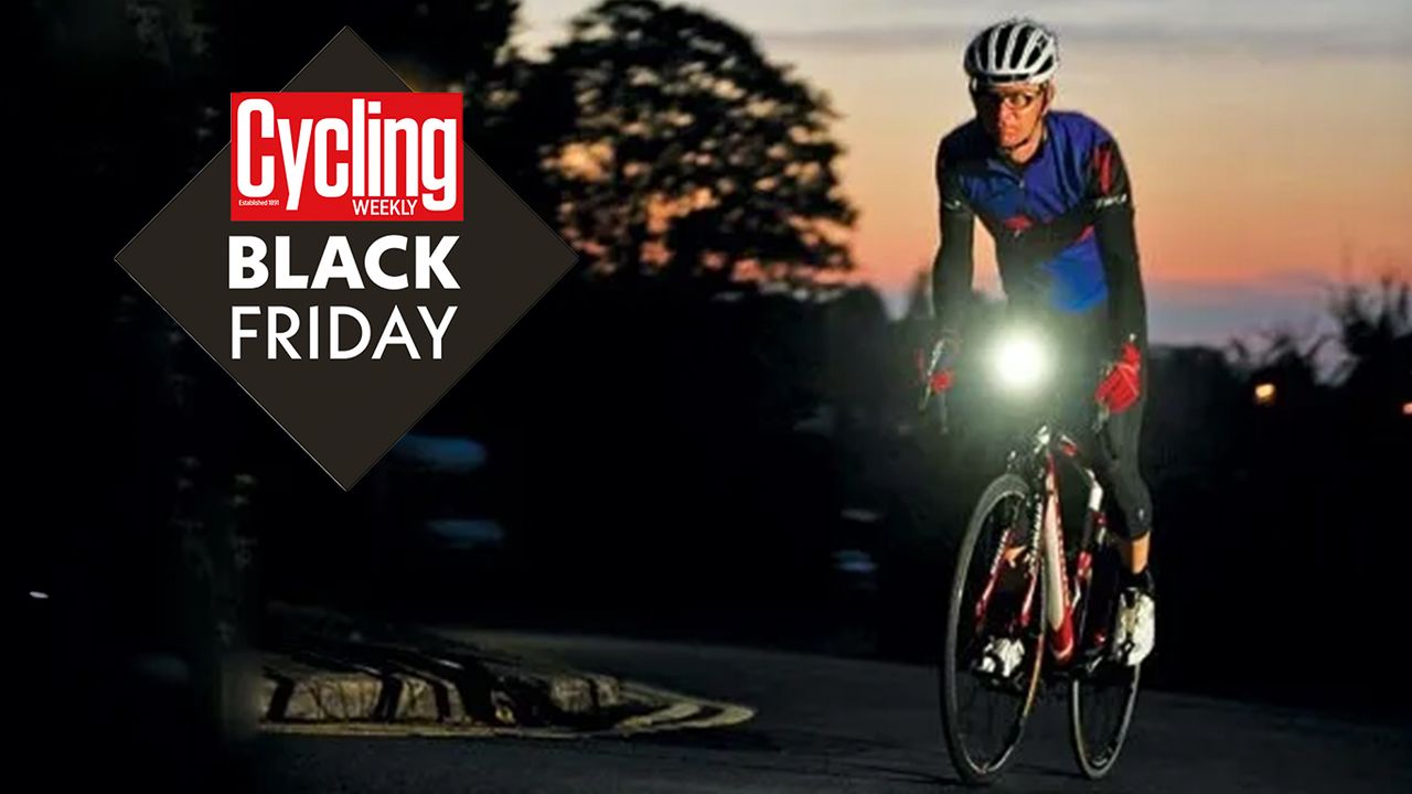 Male cyclist riding his bike in the dark with red sunset sky