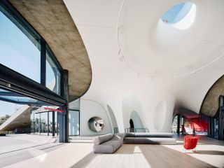 hill house montecito, flowing concrete house in the californian context with arid landscape and a tree around